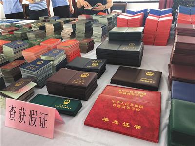 南通市公安局开发区分局小海派出所内，警方缴获的假证等赃物堆满了十几米长的桌子。新京报记者 王婧祎摄